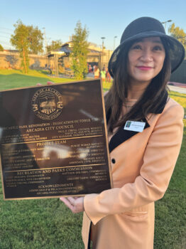 Sharon Kwan holding a plaque for the New Castle Park Renovation.