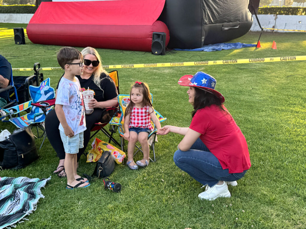 talking with children at the City 4th of July event Sharon Kwan talking to a couple of children with their mother at the City 4th of July event